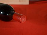a bottle of red wine on a red table cloth