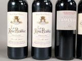 three bottles of red wine are lined up on a table