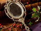 a silver mirror sitting on top of a wooden table
