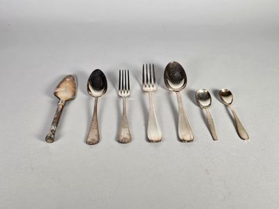 six cuillères et fourchettes sont alignées sur une table