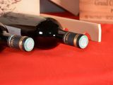 three bottles of wine sitting on a red table cloth