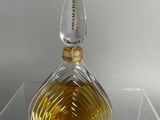 an image of a glass perfume bottle on a clear surface