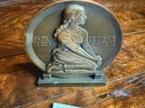 a plaque on a table that has a picture of a woman on it