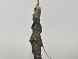 an antique bronze statue of a woman holding a lamp on a stand