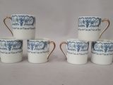 six blue and white coffee cups with gold rims