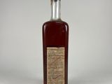 a bottle of red wine sitting on top of a white table