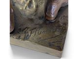 bronze statue of a man with a dog on a book