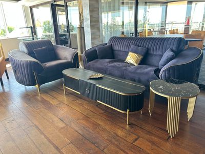 un canapé violet et deux fauteuils dans un salon