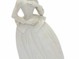 une statue blanche représentant une femme en robe blanche