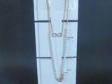 a white box with a silver necklace on it