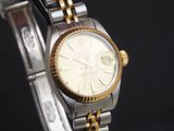 une montre-bracelet en or et en argent avec un cadran blanc