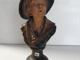 un buste de femme coiffée d'un chapeau, posé sur une table