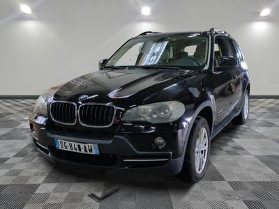 une photo d'un SUV bmw noir garé dans un garage