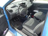 the interior of a small blue car with the door open