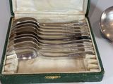 six spoons in a green case on a table