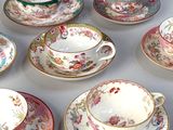 several different types of tea cups and saucers are arranged on a table