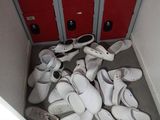 many pairs of white shoes in a room with red doors