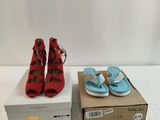 two pairs of red and blue sandals sitting on top of a box