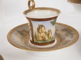 a cup and saucer on a saucer with a picture of a castle on it