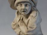 a small statue of a boy with a hat on his head