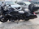bmw motorcycle parked in a parking lot with other cars in the background