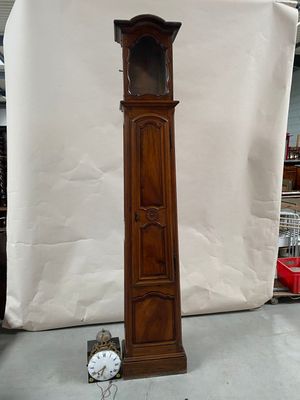 a tall wooden grandfather clock in the middle of a room