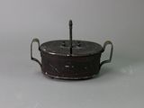 a small metal pot with a handle on a table