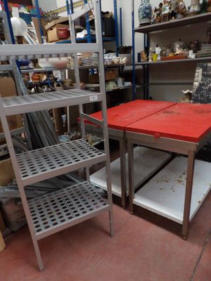 une table rouge au milieu d'une pièce remplie d'étagères