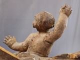 a small statue of a child sitting on a book