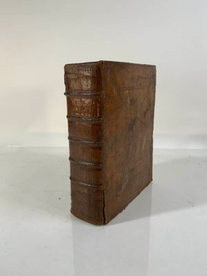 an old book sitting on top of a white table next to a white wall