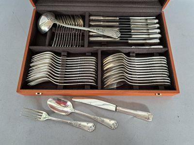 de nombreux couverts dans une boîte en bois posée sur une table