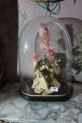 a glass clochet with flowers inside of it on a table