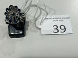 une bague ornée de pierres bleues et une étiquette de prix posée sur une table