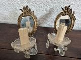 two candles that are sitting on a table with a mirror