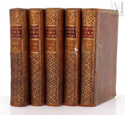 three old books are stacked on top of each other on a white surface