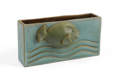 un vase vert contenant un poisson, sur fond blanc