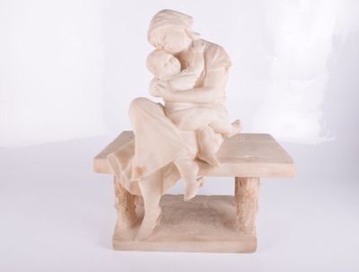 statue d'une femme assise sur un banc, tenant un bébé dans ses bras