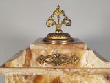 a gold and marble box with a decorative decoration on top