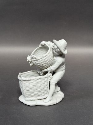 a figurine of a boy with a basket on his head