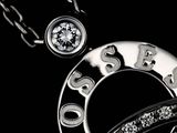 black and white photograph of a necklace and a watch on a chain