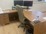 a desk with two computer monitors and a bag on it
