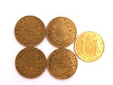 five gold coins are arranged in a row on a white surface