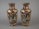 pair of vases with asian scenes on them sitting on a table