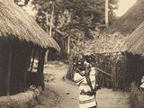 une photo en noir et blanc d'un homme marchant sur un chemin de terre