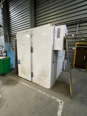 une photo d'un réfrigérateur dans un entrepôt, à côté d'autres appareils électroménagers