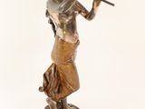 bronze statue of a woman playing a flute on a marble base