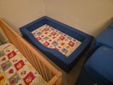 un berceau et un lit dans un coin de la pièce