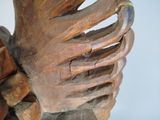 a wooden sculpture of a human hand holding a piece of wood