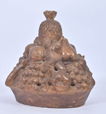 a brown vase that has a bunch of fruit in it