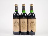 trois bouteilles de vin rouge posées sur une surface blanche